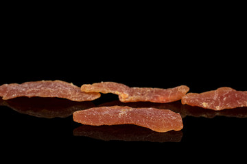 Group of four whole dried orange papaya piece isolated on black glass