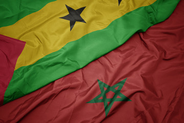 waving colorful flag of morocco and national flag of sao tome and principe .