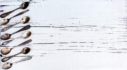 Vintage cutlery - spoons, forks and knives on an old wooden background.