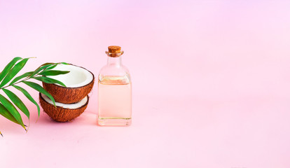 Obraz na płótnie Canvas Coconut with coconut oil on pink background. Copy space