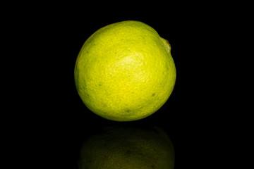 One whole ingredient guacamole lime isolated on black glass