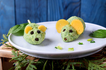Mice made of spinach and cream cheese on a ceramic plate