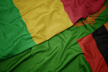 waving colorful flag of zambia and national flag of mali.