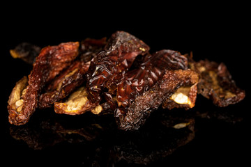 Lot of whole dried red tomato piece isolated on black glass