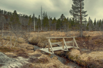 Wooden bridge over a stream on a hiking trail in the highlands of Norway  thyristic infrastructure...