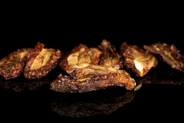 Group of seven whole dried red tomato piece isolated on black glass
