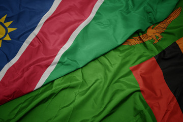 Obraz premium waving colorful flag of zambia and national flag of namibia.