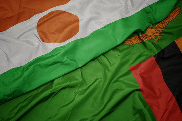 waving colorful flag of zambia and national flag of niger.