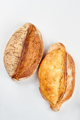 Freshly baked bread, top view. Two loaves of bread isolated on white background.