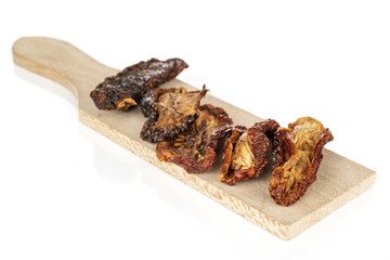 Lot of whole dried red tomato piece on wooden cutting board isolated on white background