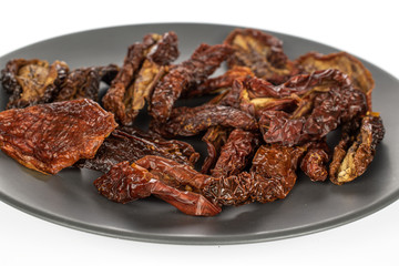 Lot of whole dried red tomato piece on gray ceramic plate isolated on white background