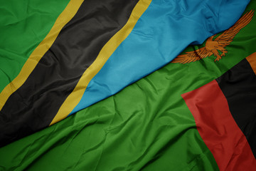 waving colorful flag of zambia and national flag of tanzania.