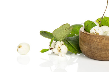 Lot of whole white snowberry in bamboo bowl isolated on white background