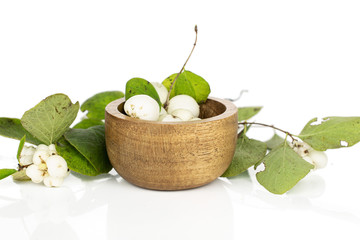 Lot of whole white snowberry in bamboo bowl isolated on white background