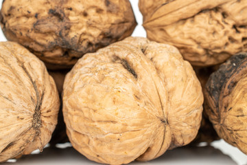 Lot of whole natural fresh brown walnut closeup isolated on white background