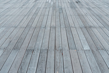 The texture of the flooring from wooden boards. Background of a street scene from wooden planks. Wooden deck. Plank floor perspective podium.