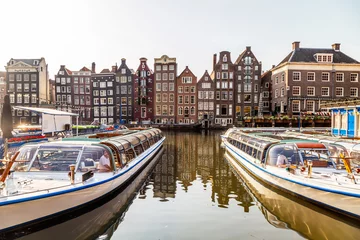 Zelfklevend Fotobehang Amsterdam boats on the canal in Damrak area © hungry_herbivore
