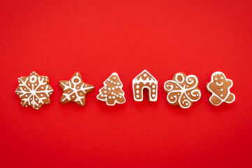 Fototapeta na wymiar Xmas gingerbread cookies on the red background. Christmas, New Year, winter concept. Christmas sweet composition. Flat lay, top view, copy space