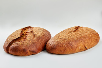 Two crusty loaves of bread on white background. Delicious homemade bread. Healthy sourdough product.