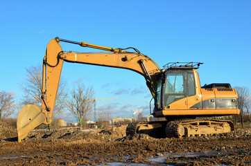 Tracked excavator working at a construction site during laying or replacement of underground storm sewer pipes. Installation of water main, sanitary sewer, storm drain systemsduring - Image