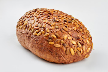 Organic wholemeal rye bread. Loaf of brown bread with pumpkin seeds. Isolated on white background.