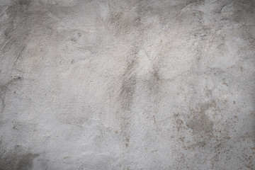Gray concrete wall texture painted with white. The old white color that has been fading and peeling off. Texture of old dirty concrete wall for background.