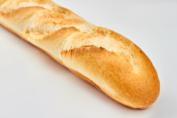 French baguette isolated on white background. Golden crust of french loaf. Freshly baked bread.