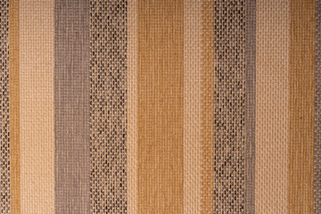 Multicolor stripes on a rough furniture fabric. Creative vintage background.