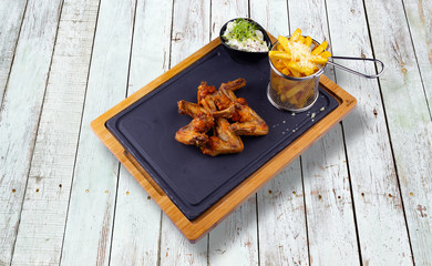 Chicken wings with fried potatoes and cabbage salad.