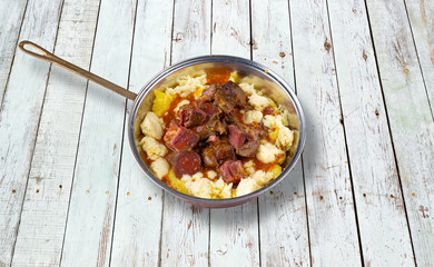 Baked sheep meat with polenta and cheese.