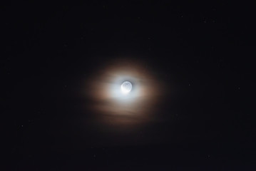 Fototapeta na wymiar The moon among the stars and clouds