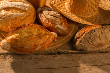 Appetizing fresh bread on wooden background. Crusty homemade loaves on vintage wooden boards background.