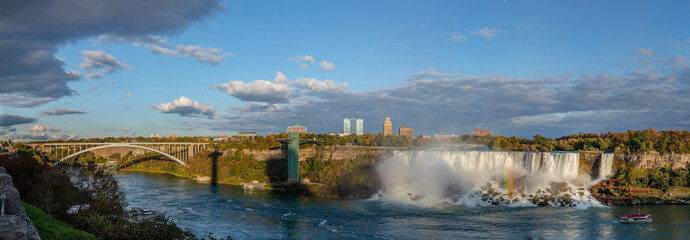 Niagara Falls - American Falls and Bridal Veil Falls with a rainbow in the sunset rays of the setting sun. View from Canadian Side