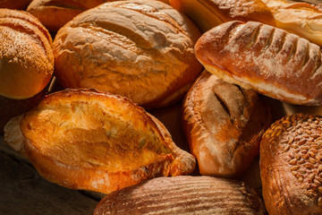 Delicious freshly baked bread close up. Assorted artisan bread background. Organic pastry store.