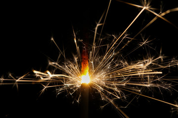 A burning sparkler with black background
