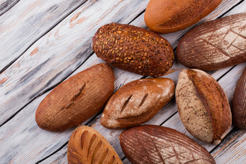 Obraz premium Organic healthy bread on wooden background. Artisan bread loaves. Homemade bread recipe.