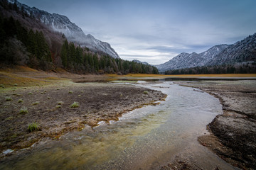 Fototapeta na wymiar Fluss am See in den Bergen - Alpen im Winter