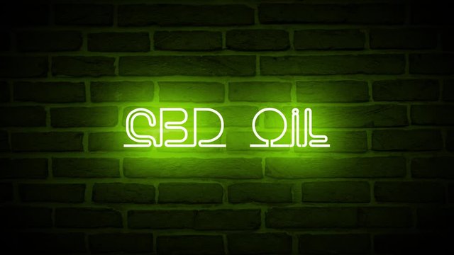 A CBD OIL glowing neon sign animated against a brick wall.