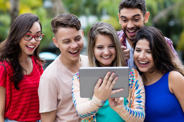 Fototapeta premium Bllondin Studentin mit Tablet und Freunden