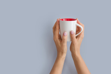 Woman's hands holding up a white cup