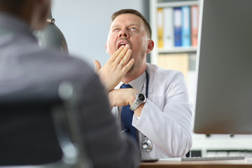 Doctor yawns while the patient has been talking about his problems for an hour.