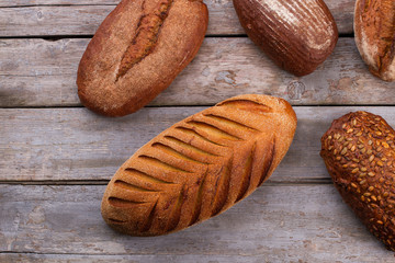 Artisan bread on rustic wooden background. Natural whole grain bread on wooden boards.