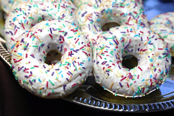 Feshly baked homemade donut in rows on plate at local bakery shop