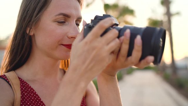 Photographer tourist woman taking photos with camera in a beautiful tropical landscape at sunset