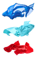 Collage with different flying fabrics on white background