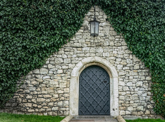 Antique wrought iron door and brick wall. Old English traditional architecture