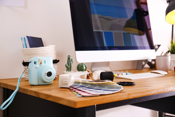 Digital camera and color palette on table in studio. Modern designer's workplace
