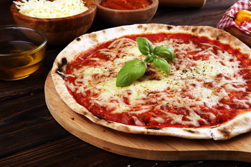 Pizza with tomatoes, mozzarella cheese, basil. Delicious italian pizza on wooden pizza board.