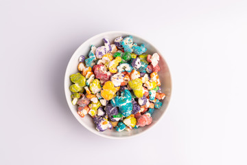 Colored Popcorn candy isolated on white background, soft light, studio shot, copy space. Junk food, fruit flavored popcorn. Colorful, multicolor, candy coated popcorn