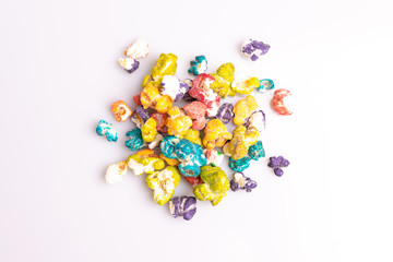 Colored Popcorn candy isolated on white background, soft light, studio shot, copy space. Junk food, fruit flavored popcorn. Colorful, multicolor, candy coated popcorn